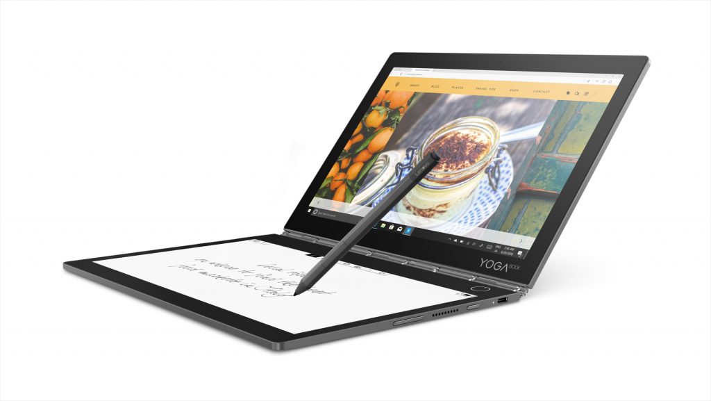Lenovo Yoga Book C930 open, with a pen hovering above, sketching notes on the E Ink screen while an image of a dessert is on the other display