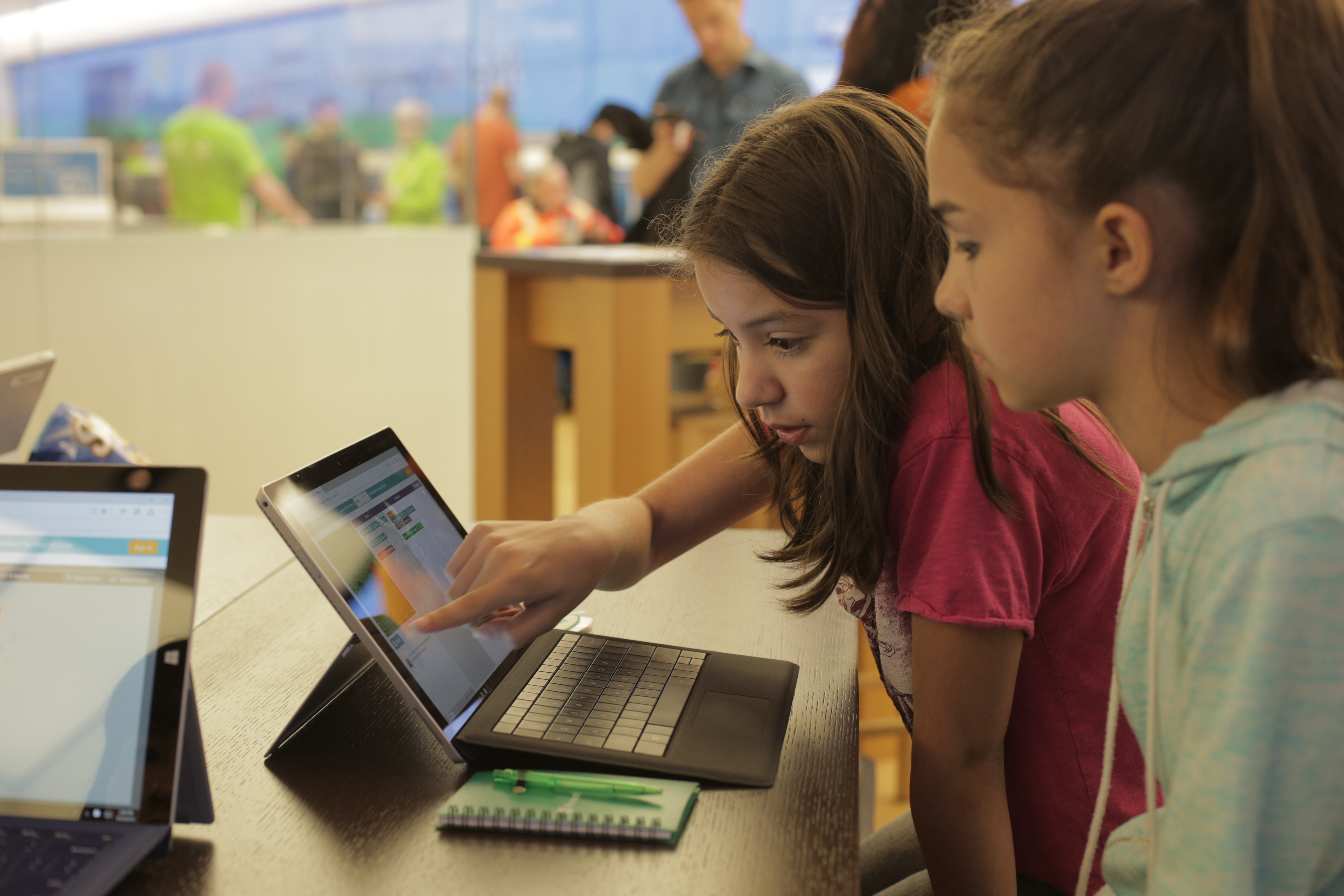 Two young students at Microsoft Store interacting with a Microsoft Surface.