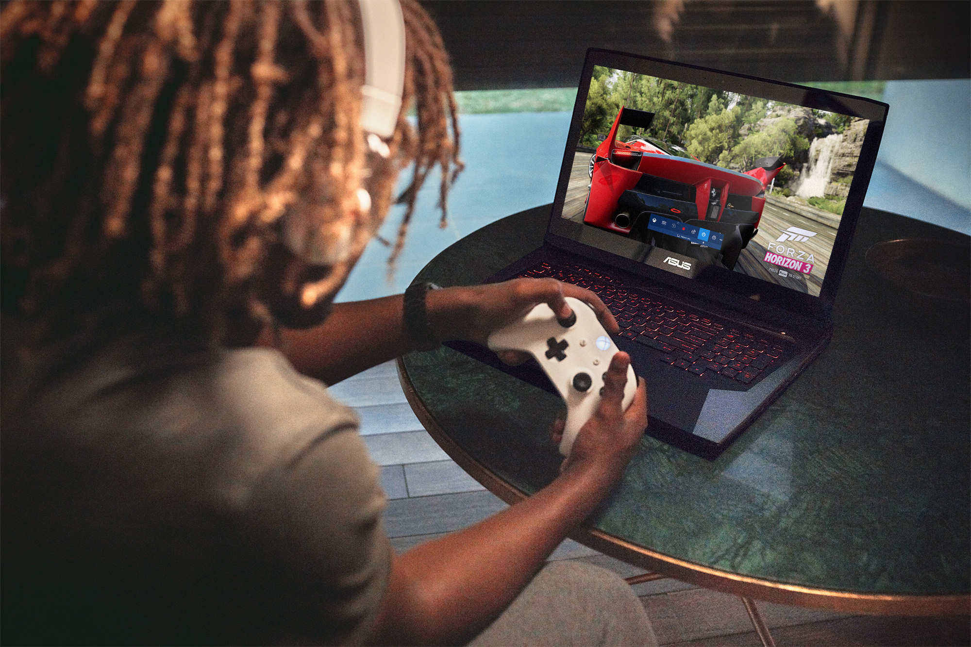 Person sitting down gaming on a Windows 10 PC with an Xbox controller