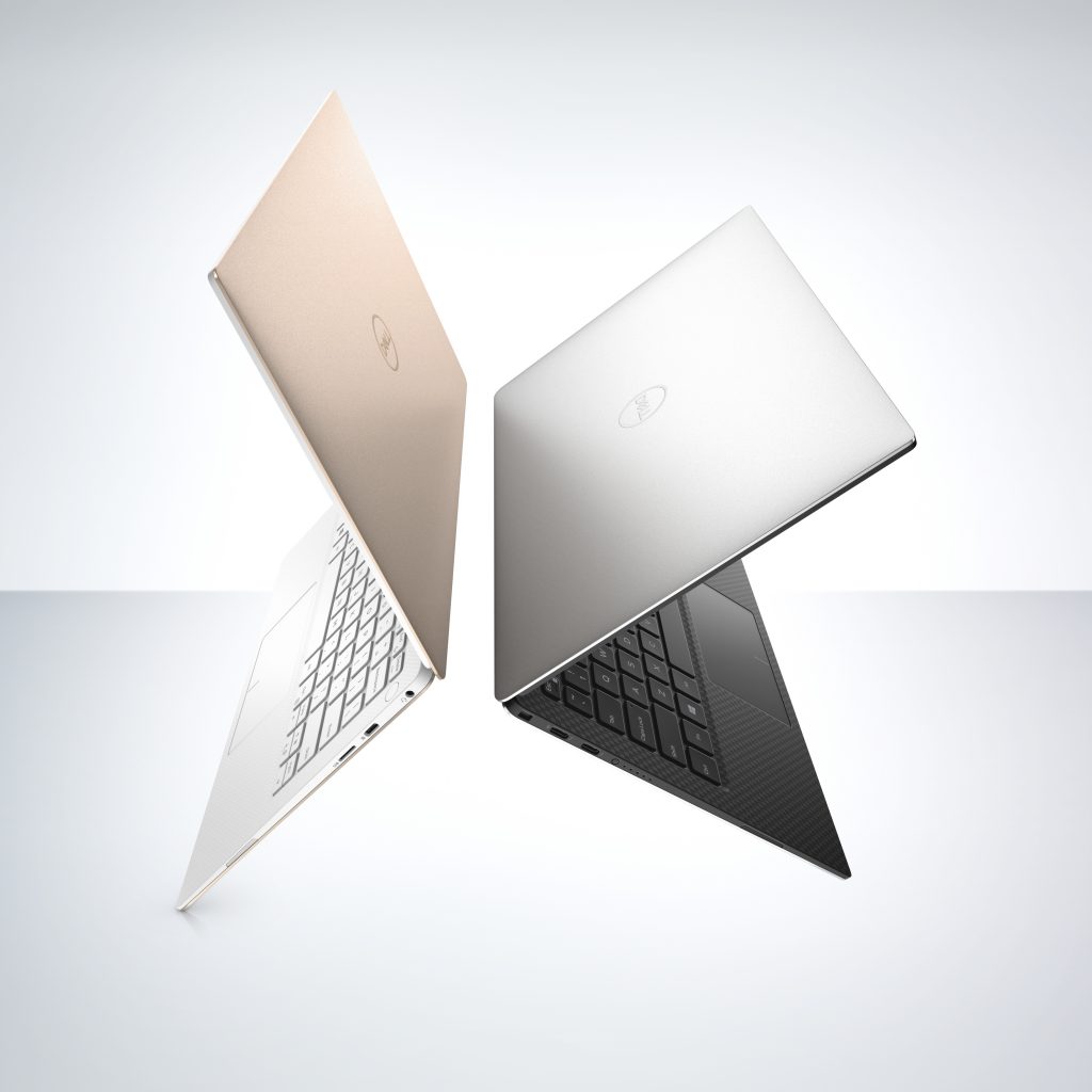Two Dell XPS PCs back to back on a grey background, one device is rose gold in color and the other grey
