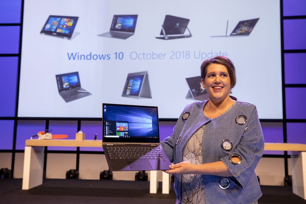 Erin Chapple, corporate vice president, Microsoft, speaking at the IFA 2018 keynote in Berlin, with displays of laptops and other devices behind her on the stage