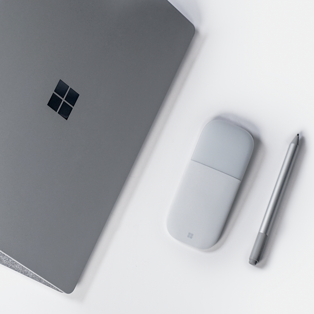 プラチナカラーのSurface Laptop、Surface Arc MouseとSurface ペンがデスクの上で並んでいる