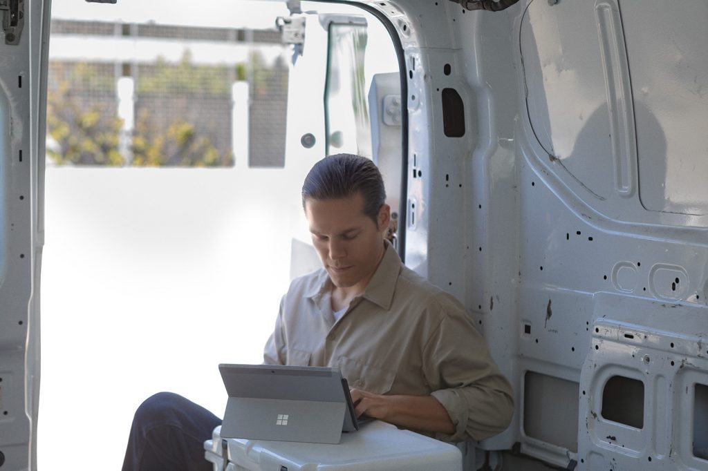 Man working on a Surface Go device in a remote location