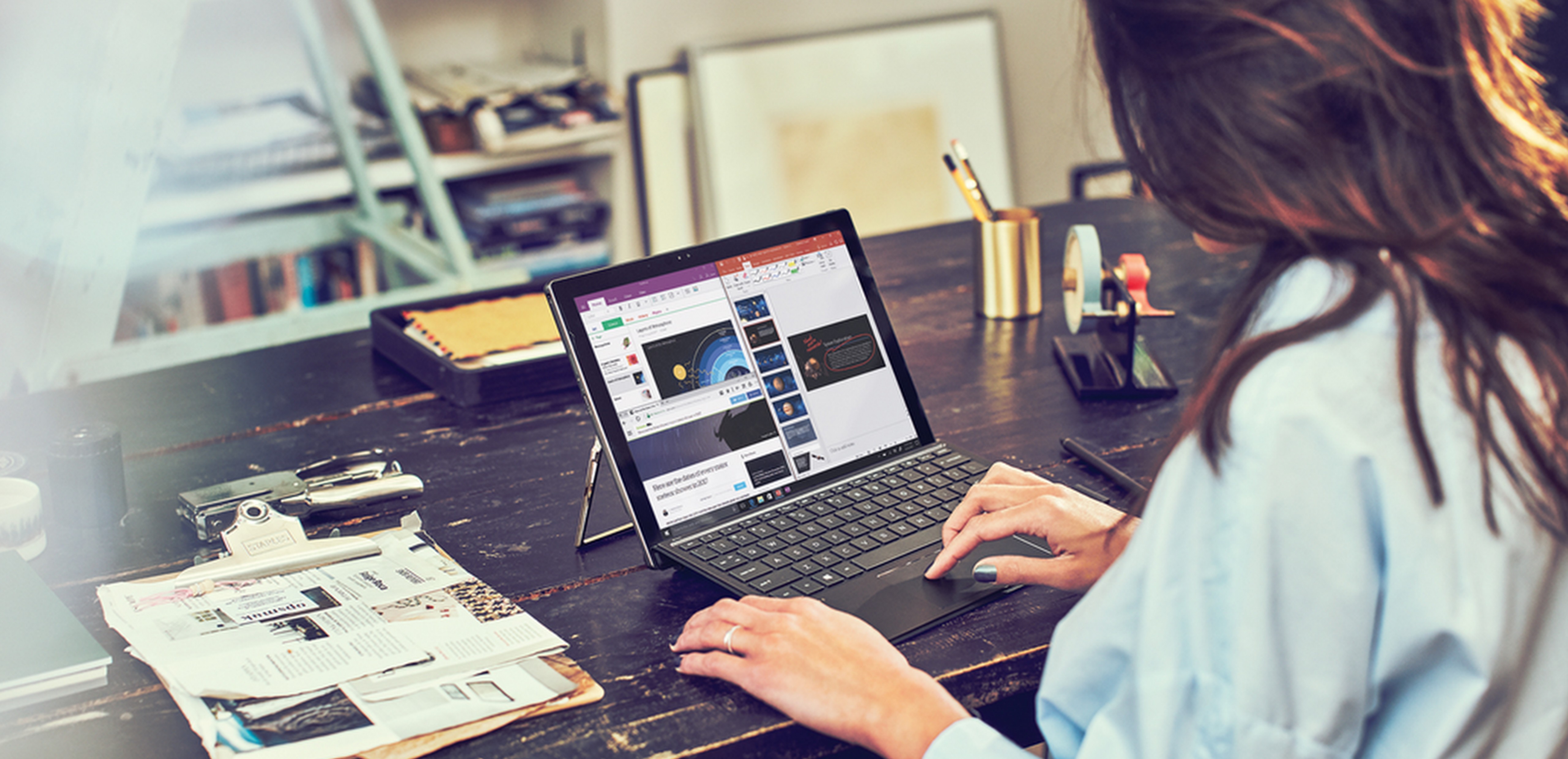 Woman sitting at a table working on an HP Spectre X2