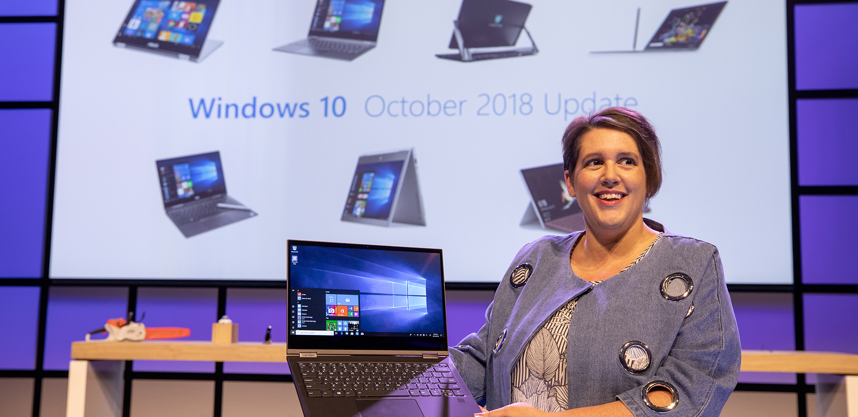 Erin Chapple, corporate vice president, Microsoft, speaking at the IFA 2018 keynote in Berlin, with displays of laptops and other devices behind her on the stage