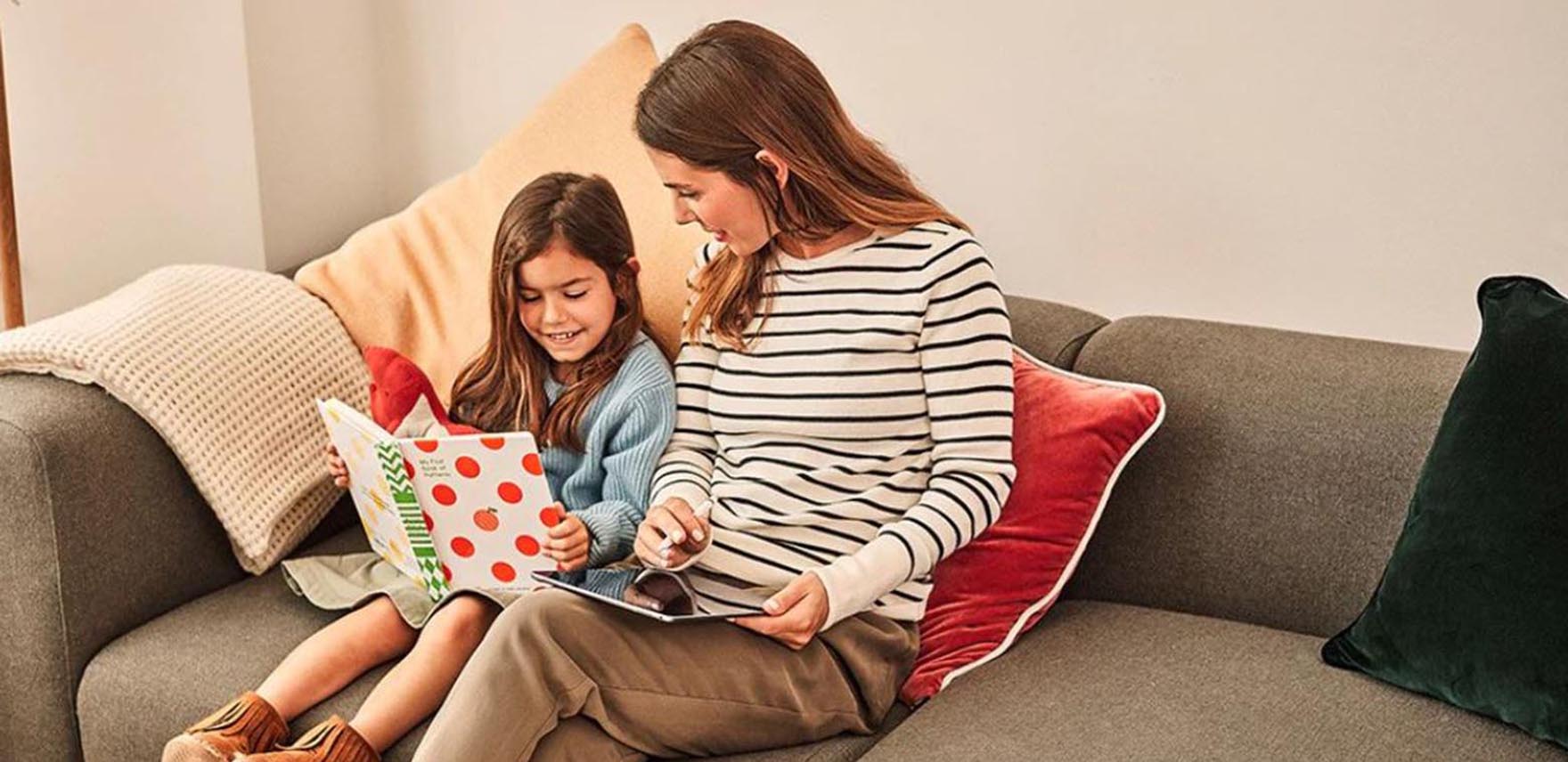 Mother and daughter reading on a couch