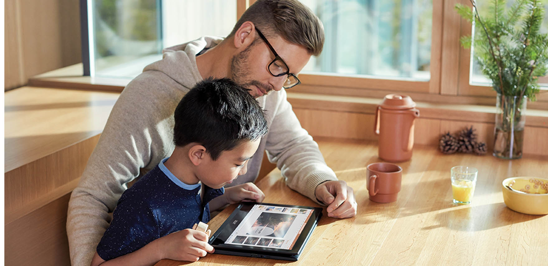 Father and son working together on a tablet device