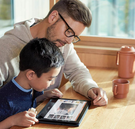 boy with his father looking at a tablet