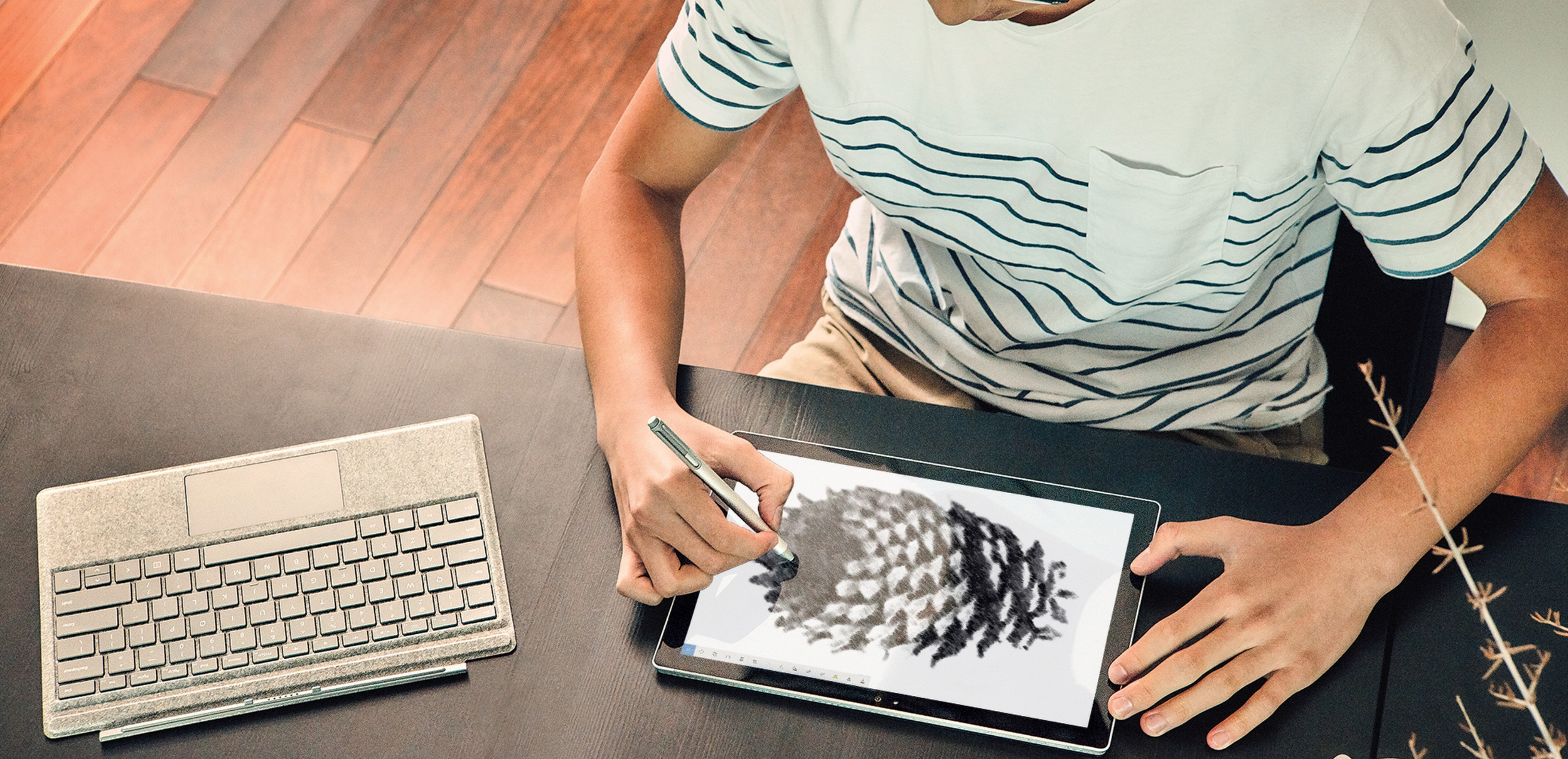 Man sitting at a desk drawing on a Surface with Surface Pen.
