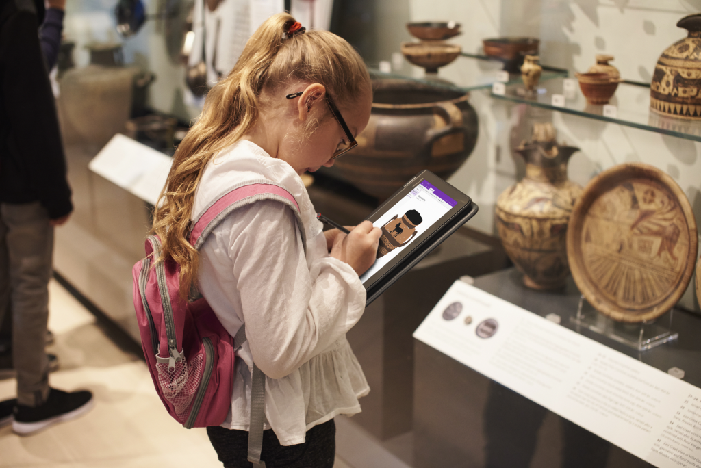 Young girl in a museum inking on a pen enabled Windows 10 PC