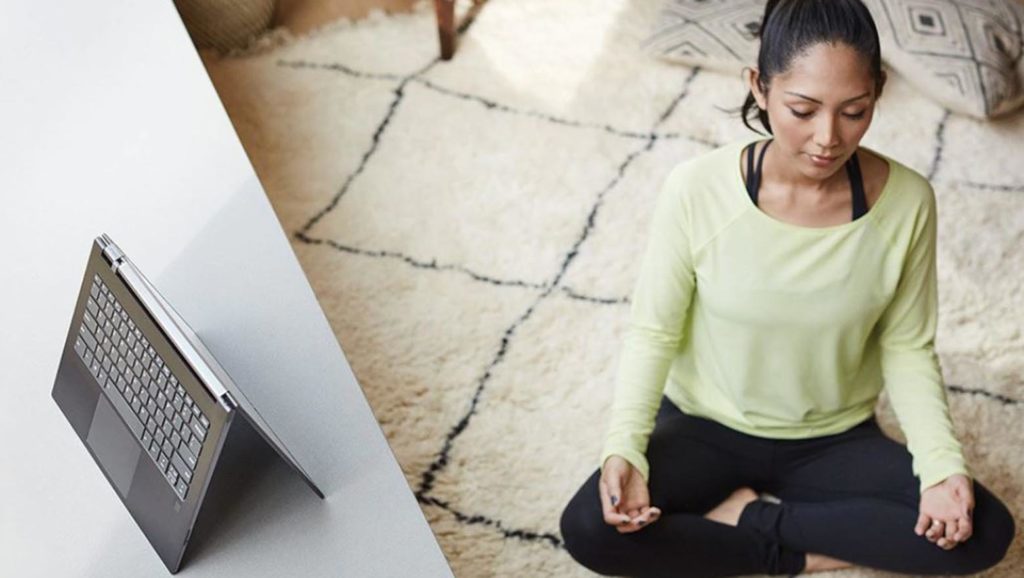 Woman meditating next to a mobile device