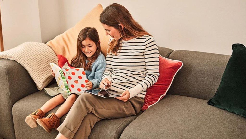 Mother and daughter reading on a couch