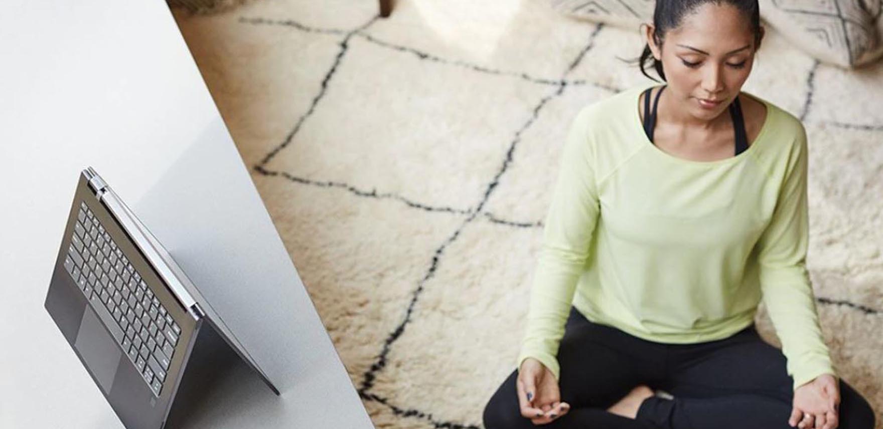 Woman meditating next to a mobile device