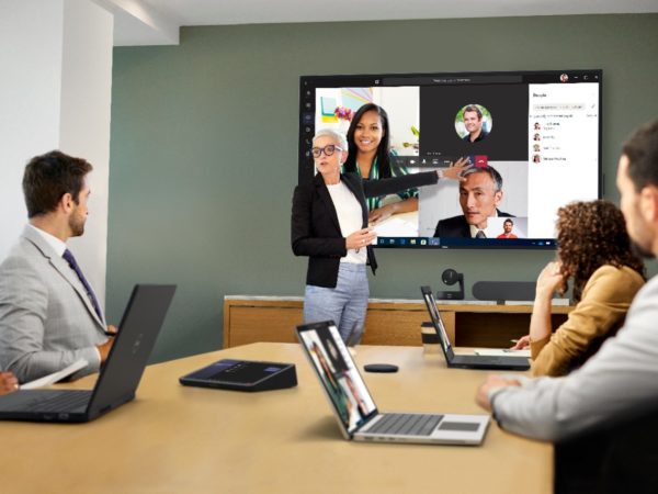 Woman leading meeting in a room with Microsoft Teams on screen behind her
