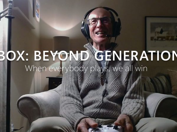 Grandfasther wearing headset and holding Xbox controller