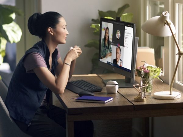 Asian woman at a desk engaged in a video call on an OptiPlex monitor