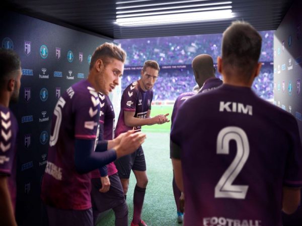 Football players look to their manager in a tunnel entering a stadium