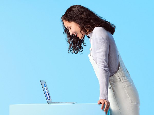 Smiling woman looking down at a laptop computer