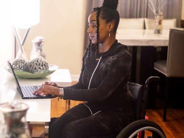 Woman in a wheelchair interacting with her laptop computer