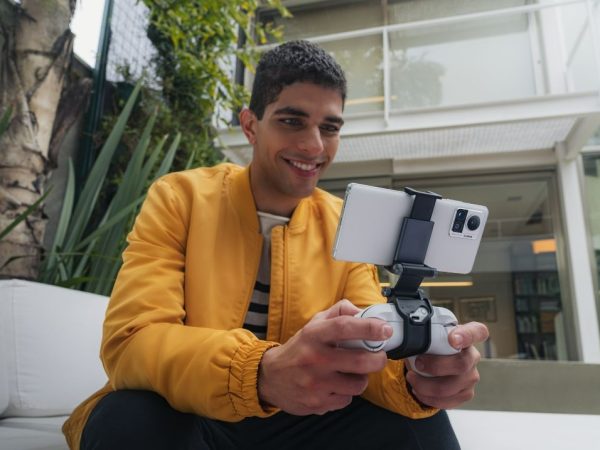 Man holding controller and playing on a smartphone attached to it