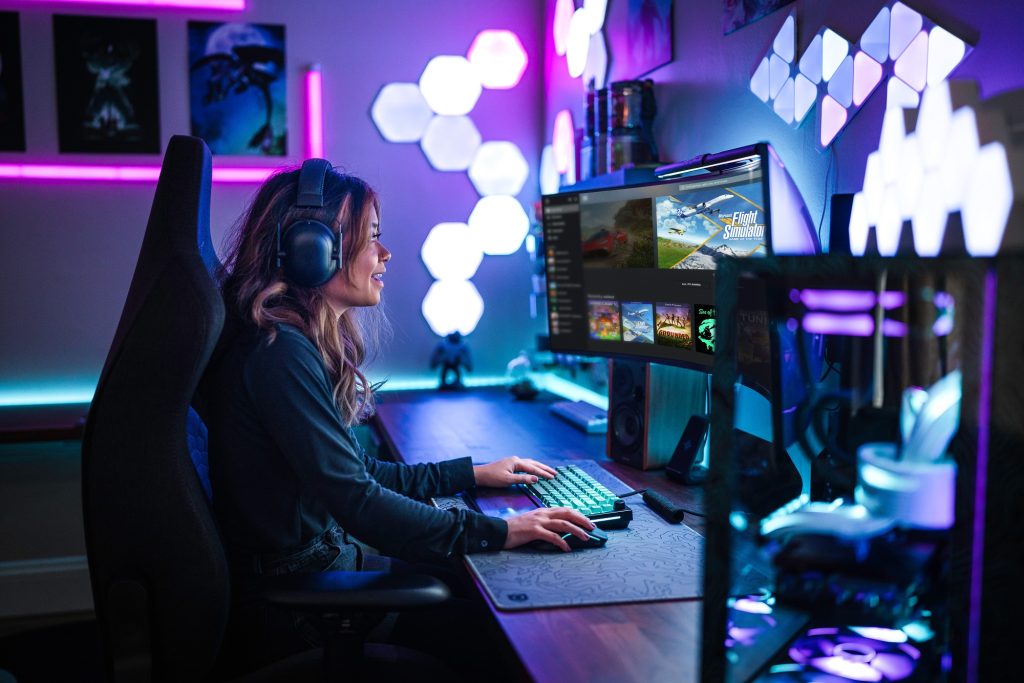 Woman in a dimly lit room playing games on a PC