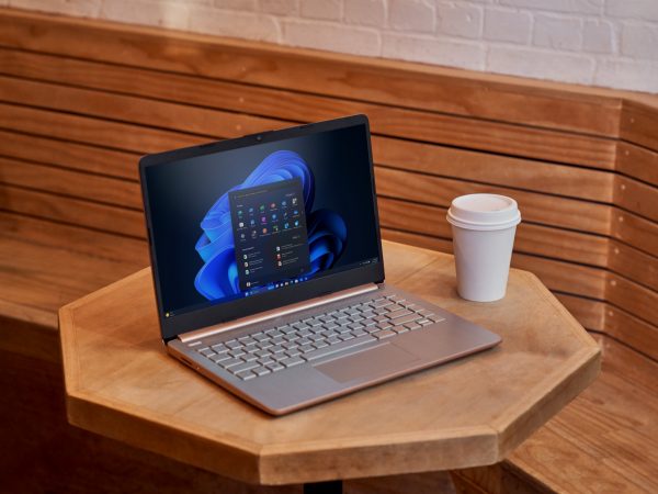 Laptop running Windows 11 on a table next to a cup of coffee