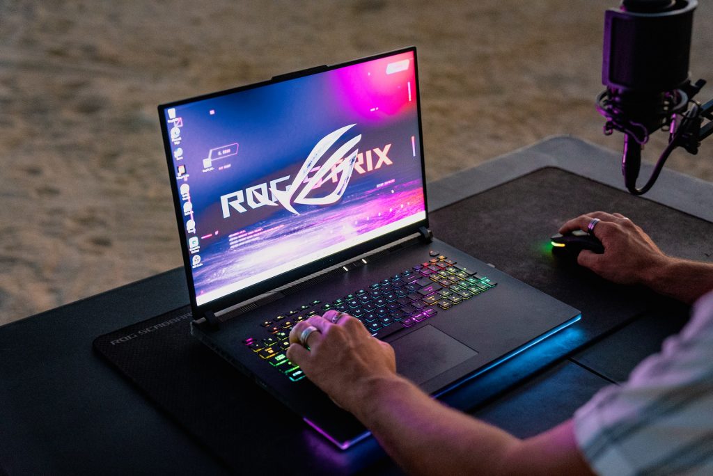 Close-up of a laptop with keys lit up and ROG Strix logo on screen