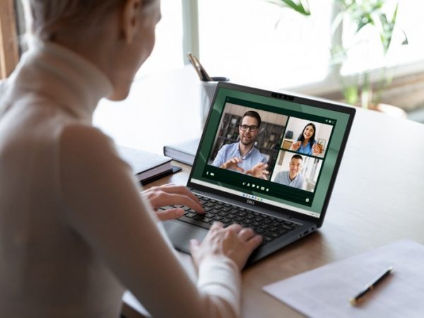 Woman engaged in a video conference call, as seen from behind and above