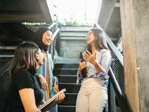 Three young women talking on a stairwell