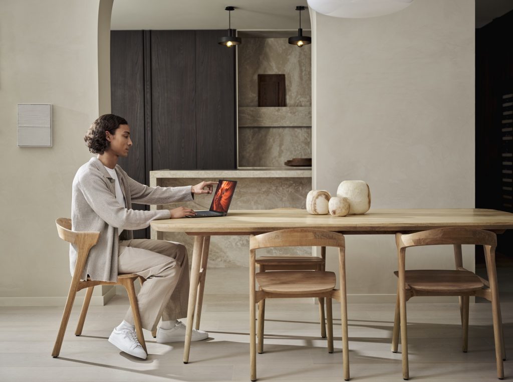 Man sitting at a table working on a laptop