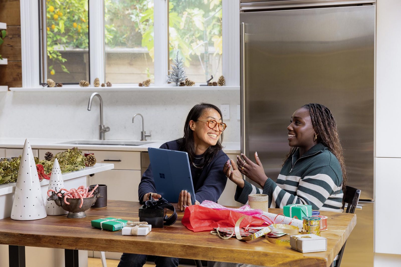 Two women talking as they wrap presents in a kitchen