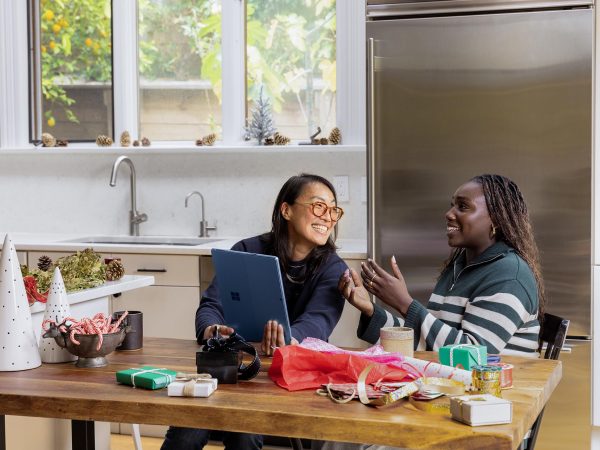 Two women talking as they wrap presents in a kitchen