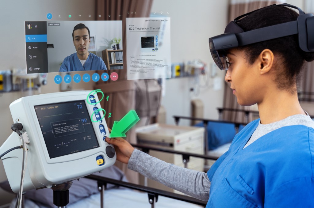 HoloLens 2 を装着した人が、医療機器の前に立って、遠隔支援により作業をしている様子