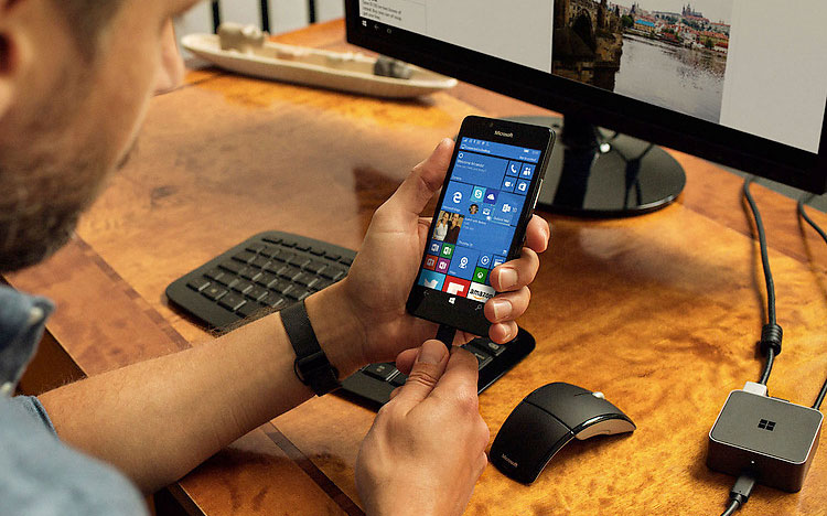 A man plugs a Lumia 950 into a screen using Microsoft Display Dock