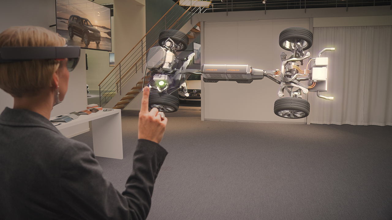 A woman is playing around with car models using Microsoft HoloLens.