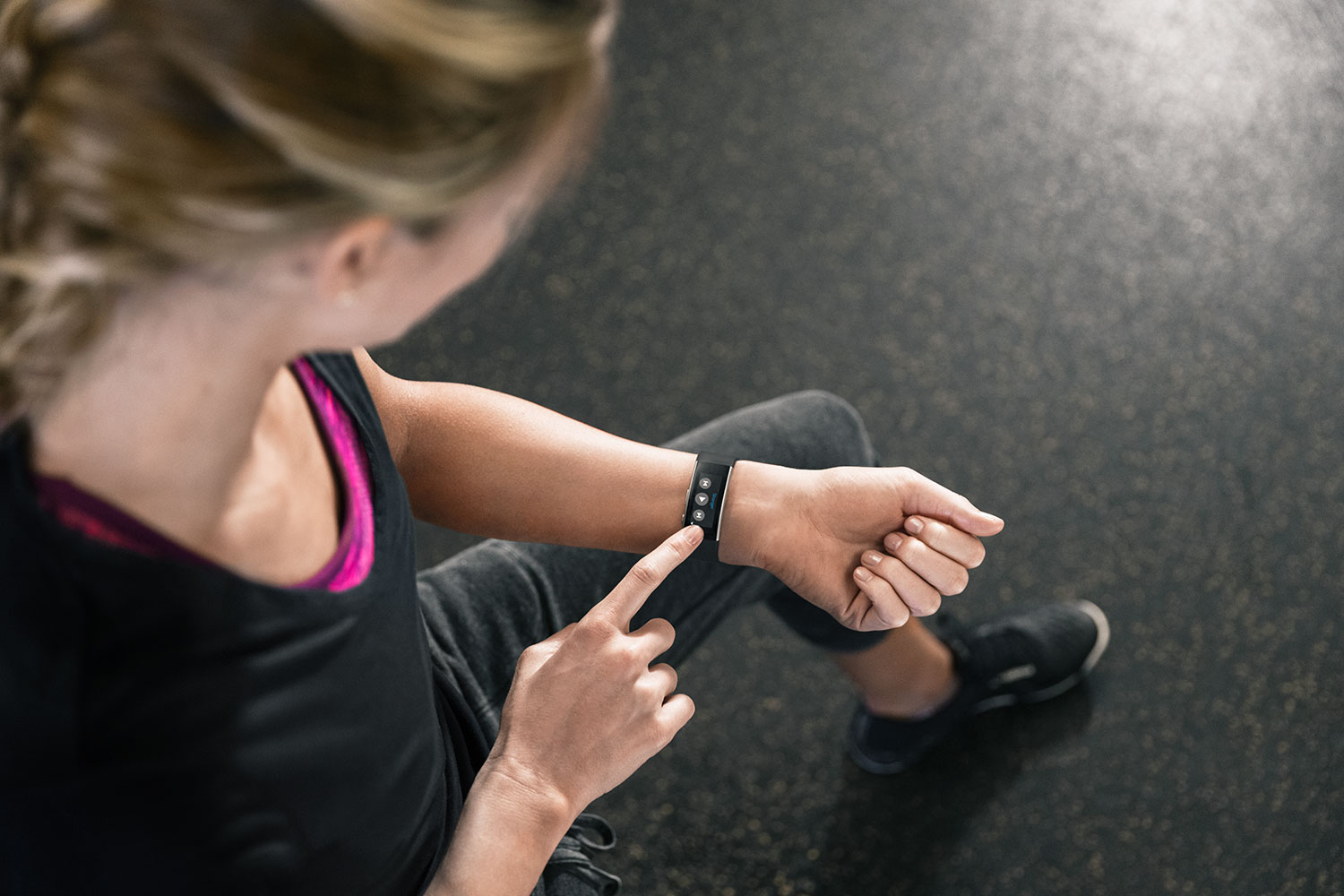 A girl is using the new Microsoft Band and music controls at the gym