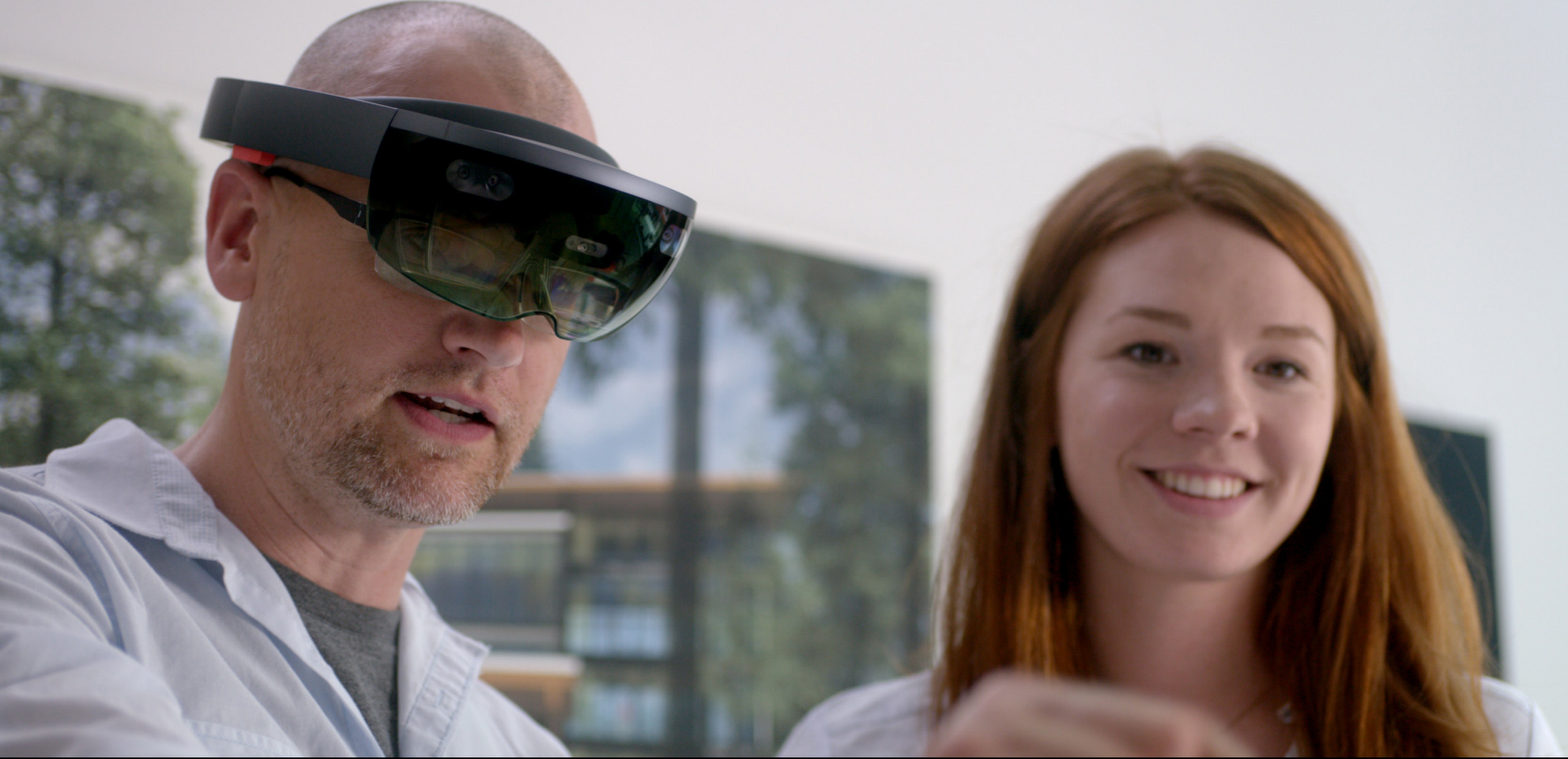 Man wearing Microsoft HoloLens standing next to woman.