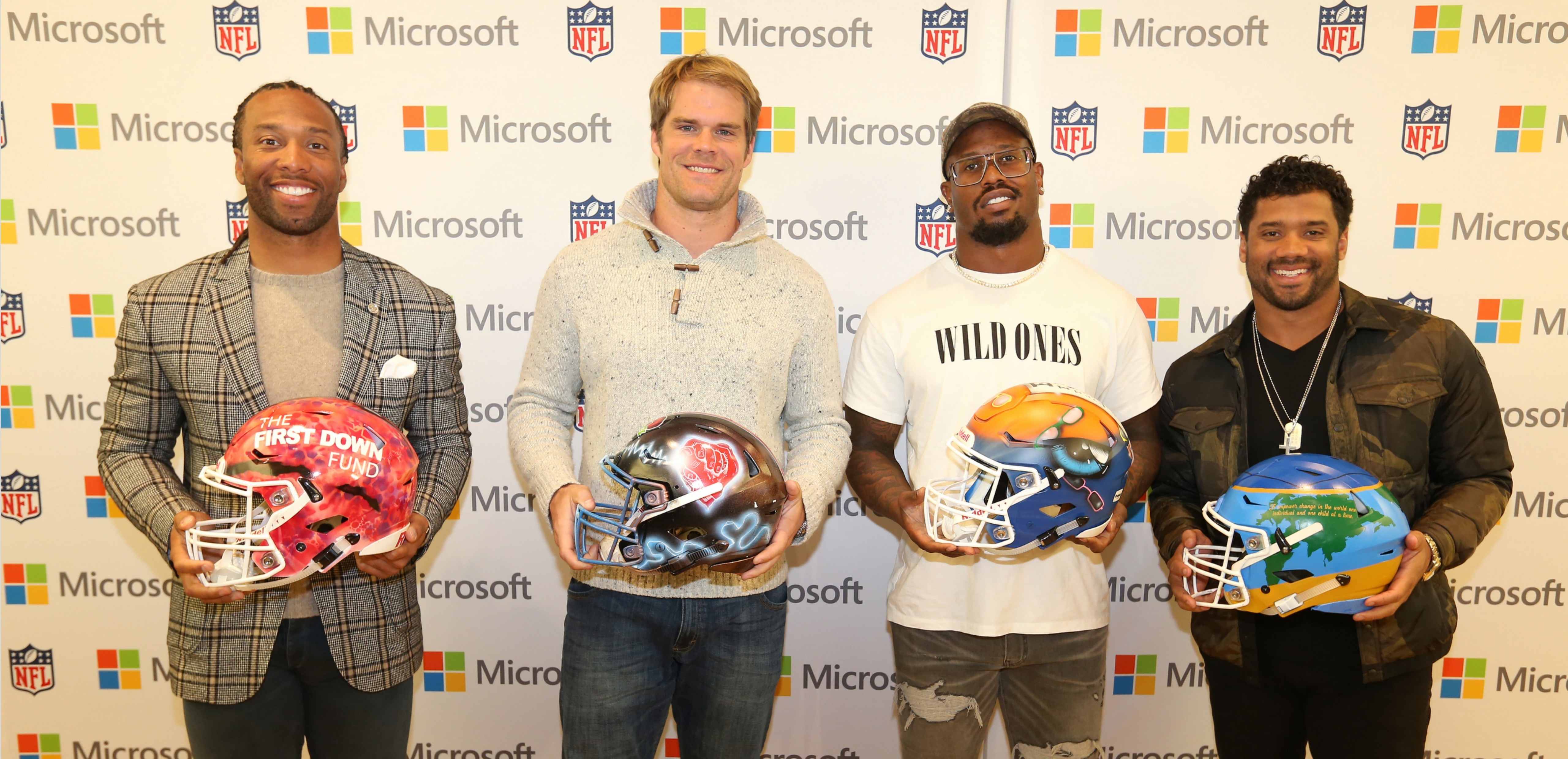 NFL players Larry Fitzgerald, Greg Olsen, Von Miller, and Russell Wilson pose with their custom designed helmets