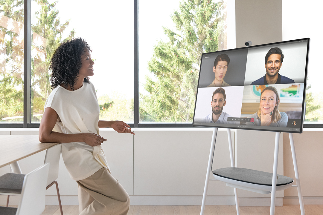 Woman meeting with others using a Surface Hub 2S