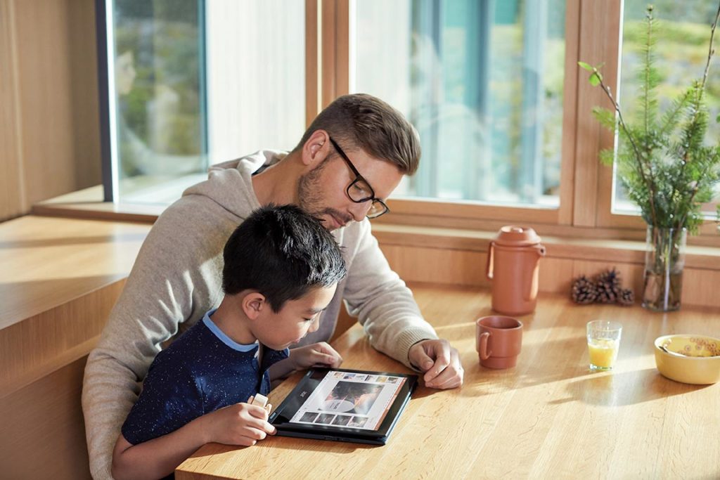 Padre e hijo trabajan juntos en una tableta